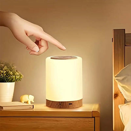 Hand touching a night light on a bedside table with a warm glow.