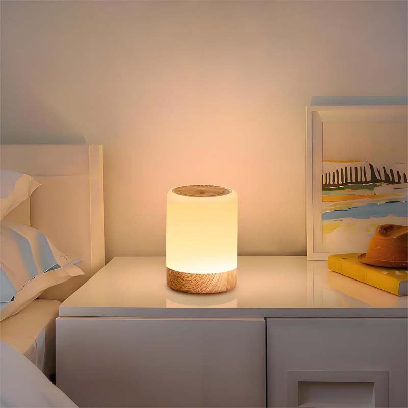 Table lamp on a nightstand next to a bed with a painting in the background