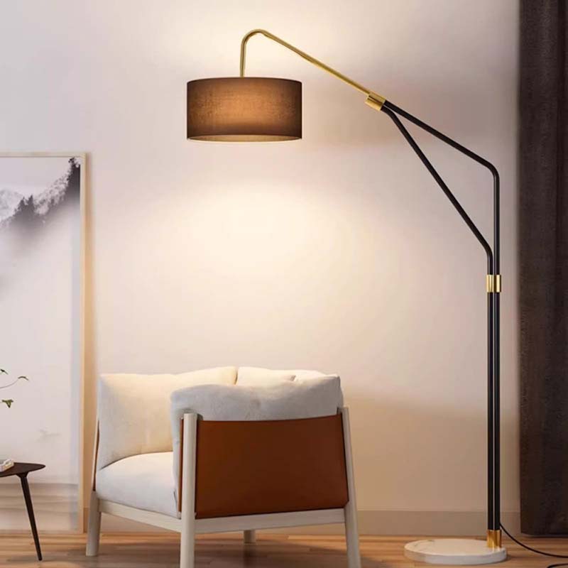 Modern floor lamp with a brown shade next to a white armchair in a room.