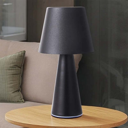 Black table lamp on a wooden table with a blurred background