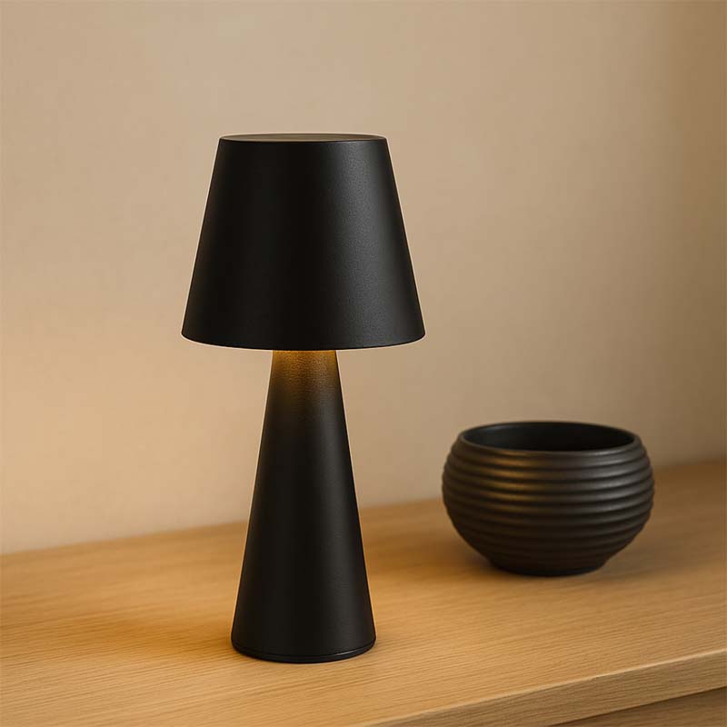Black table lamp and bowl on a wooden surface with a beige background