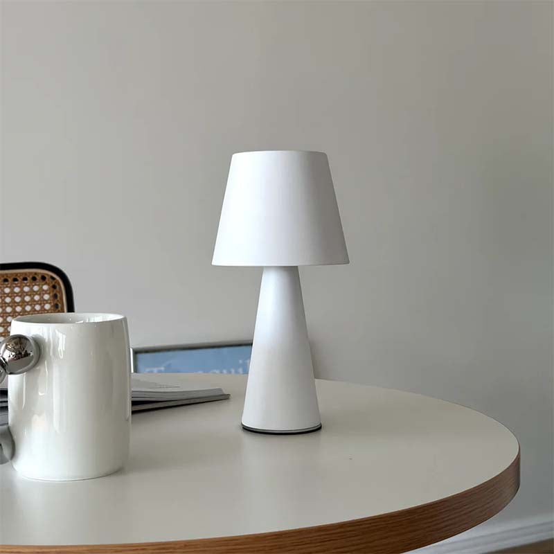 White table lamp and mug on a wooden surface with a neutral background