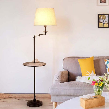 Rotating floor lamp with mini shelf next to a gray sofa in a living room
