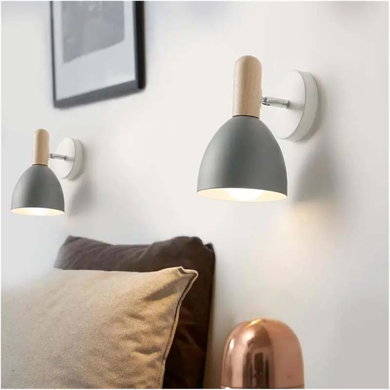 Two wall-mounted lamps with gray shades and wooden accents on a white wall.