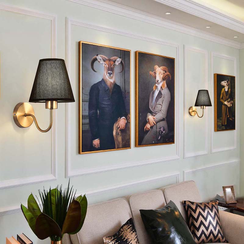 Wall art of animals in suits displayed on a wall with decorative lighting.