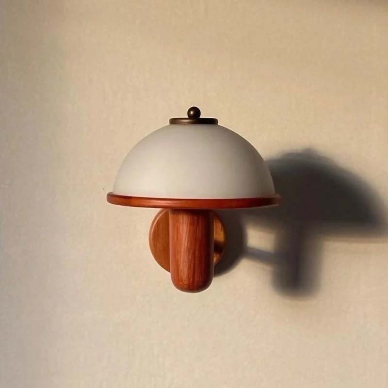 Wall-mounted light fixture with wooden base and white shade on a beige wall.