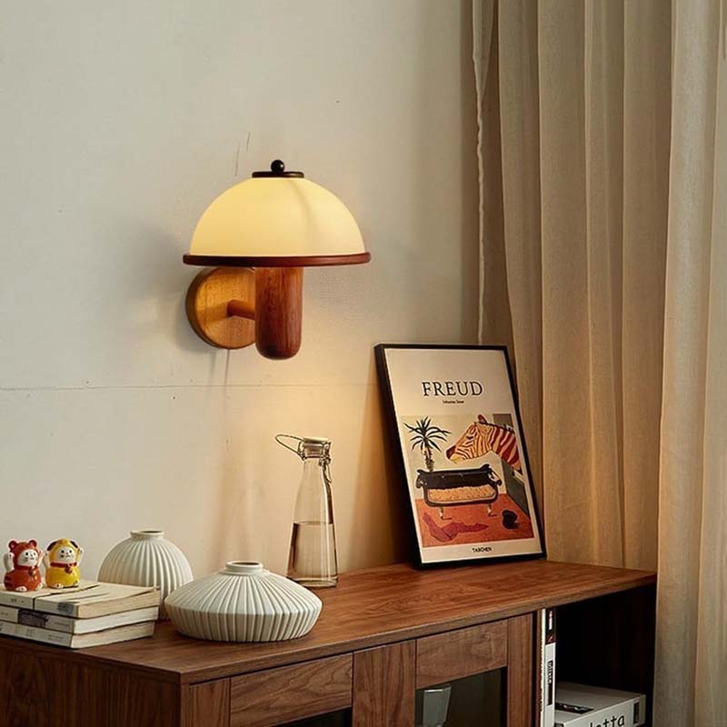 Wall lamp above wooden shelf with decorative items and framed painting.