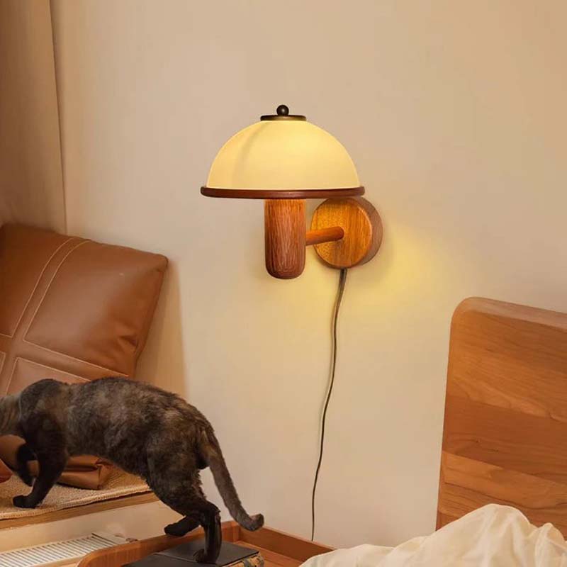 Wall-mounted lamp with a cat walking on a wooden stool in a room.
