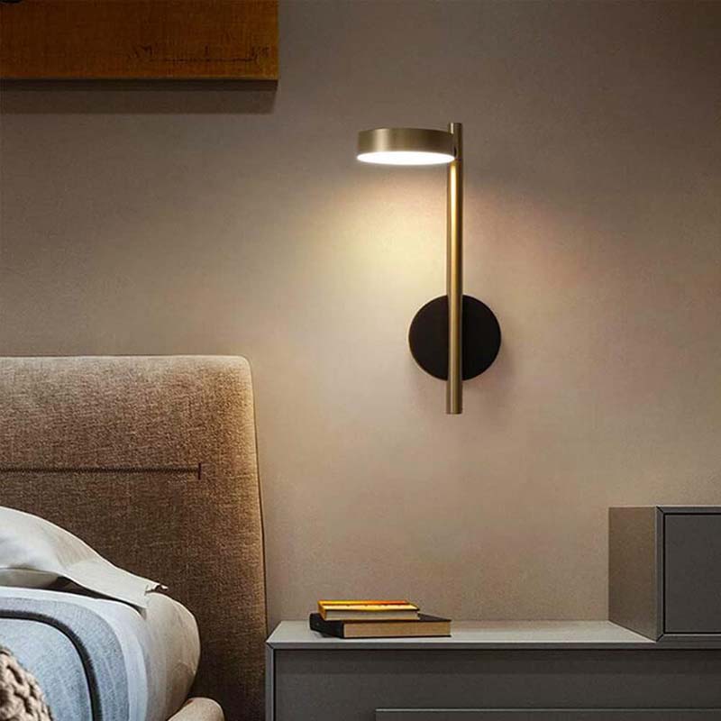 Modern wall-mounted lamp in a bedroom setting with a bed and nightstand.