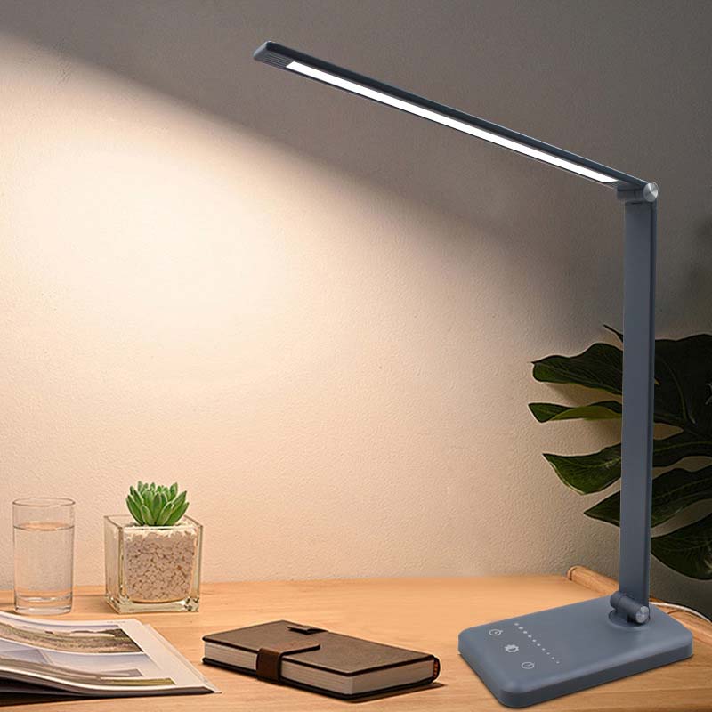 Blue LED desk lamp on a wooden surface with a plant and glass in the background