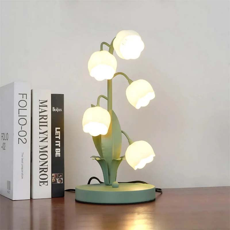 Decorative table lamp with multiple light bulbs on a wooden surface.