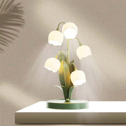 Decorative table lamp with white bulbs and green base on a neutral background