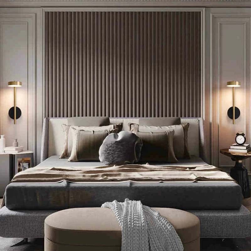 Modern bedroom with a bed, side tables, and wall lamps.