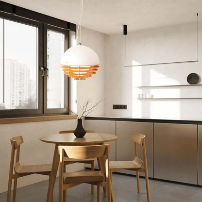 Sunset pendant lamp above a round dining table in a bright minimalist interior.