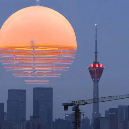 Sunset pendant light turned on with warm glow against a city background
