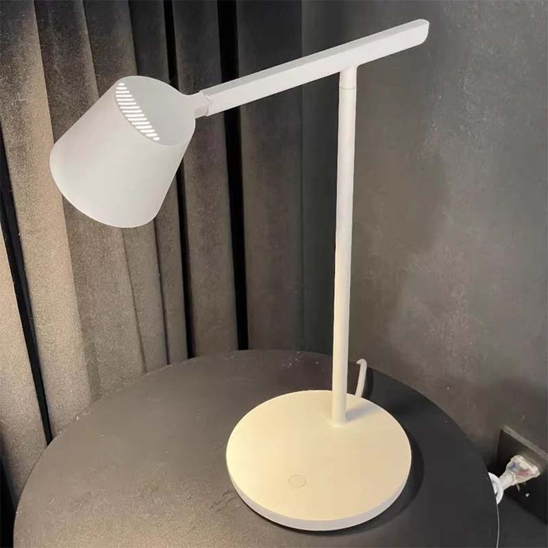 Modern desk lamp on a round surface with a neutral background
