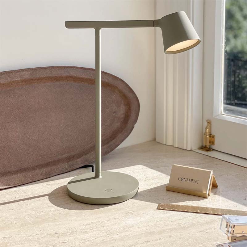 Modern gray desk lamp on a wooden surface with a blurred background
