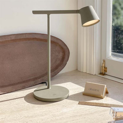 Modern gray desk lamp on a wooden surface with a blurred background