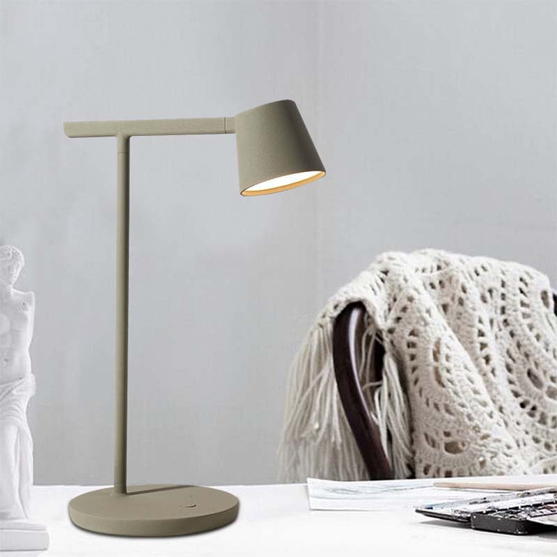 Modern desk lamp on a white surface with a light gray wall in the background