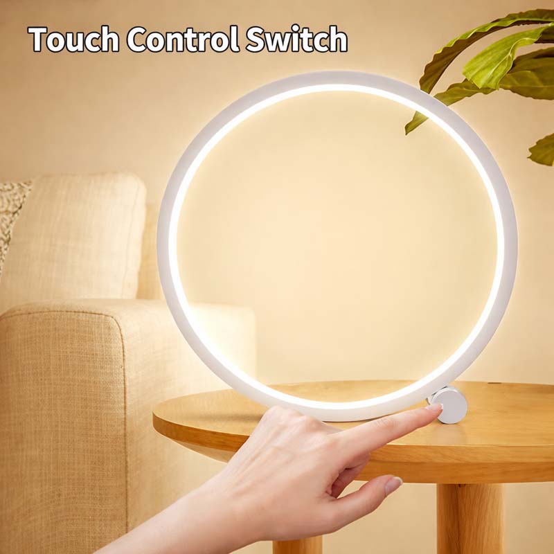 Round touch switch is operated by hand on a lamp placed on a wooden table in a home interior setting.