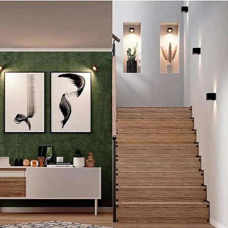 Touch LED Wall Sconce in a modern interior with a wooden staircase, green wall and decorative elements.