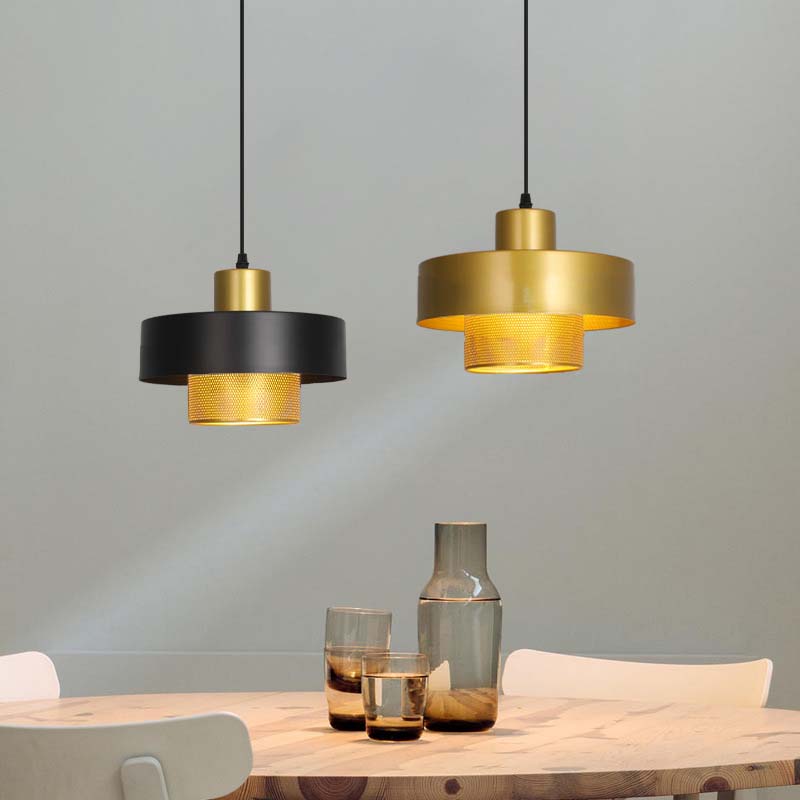 Two Black & Gold Pendant Lights above a table against a grey wall.