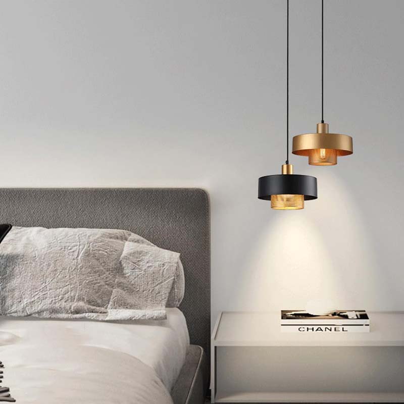 Two Black & Gold Pendant Lights in a bedroom on a gray wall.