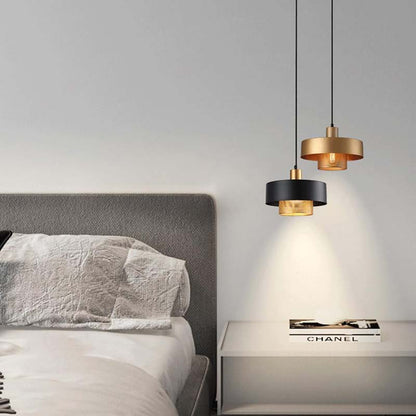 Two Black & Gold Pendant Lights in a bedroom on a gray wall.