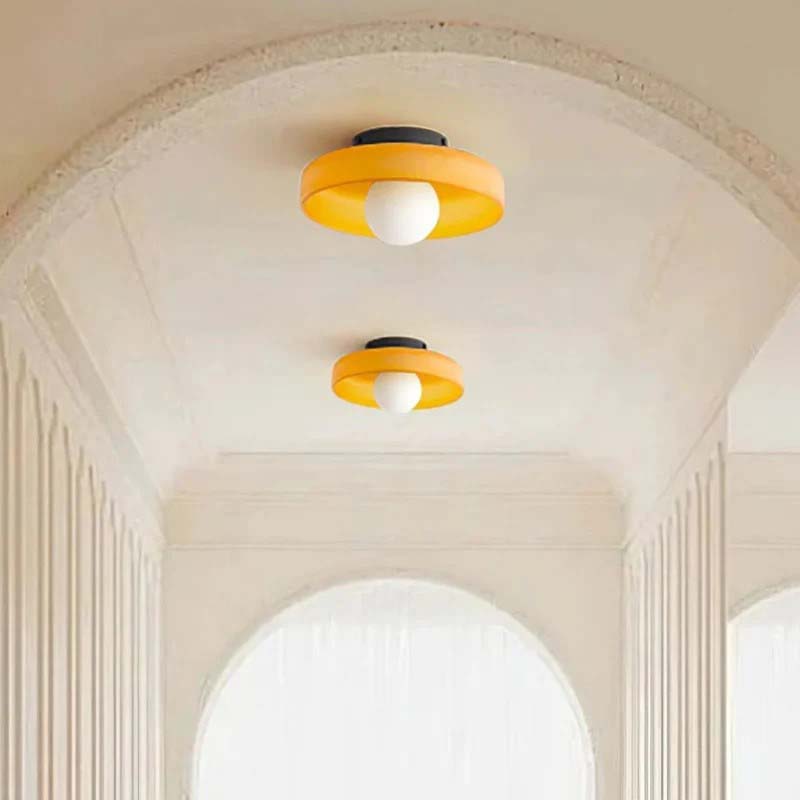 Two orange ceiling lights on a white ceiling with decorative arches.