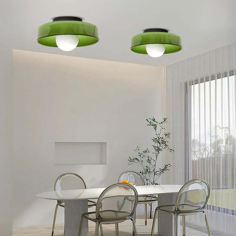Two green glass ring ceiling lights in a bright room above a table
