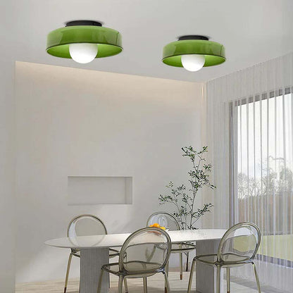 Two green glass ring ceiling lights in a bright room above a table