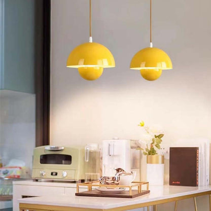 Modern kitchen with yellow pendant lights, white countertop, and green appliance.