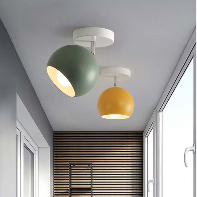 Two colorful ceiling lights in a room with a window and radiator.