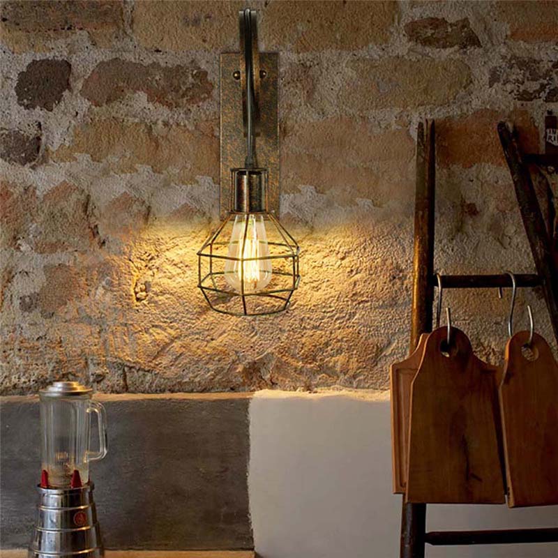 Wall-mounted industrial-style light fixture on a stone wall with a ladder and metal container in the foreground.