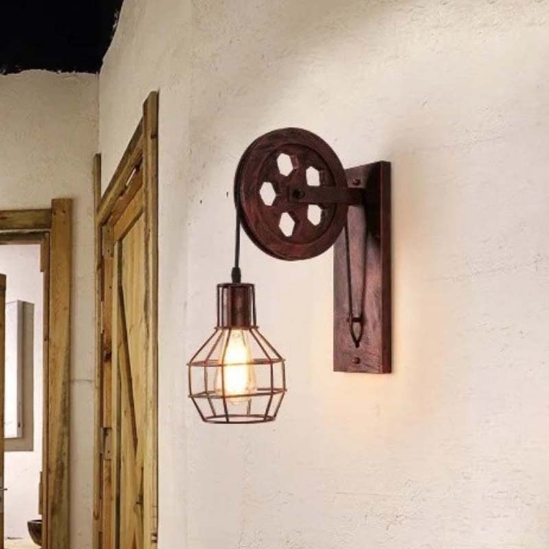 Vintage-style wall lamp with pulley design on a textured wall.