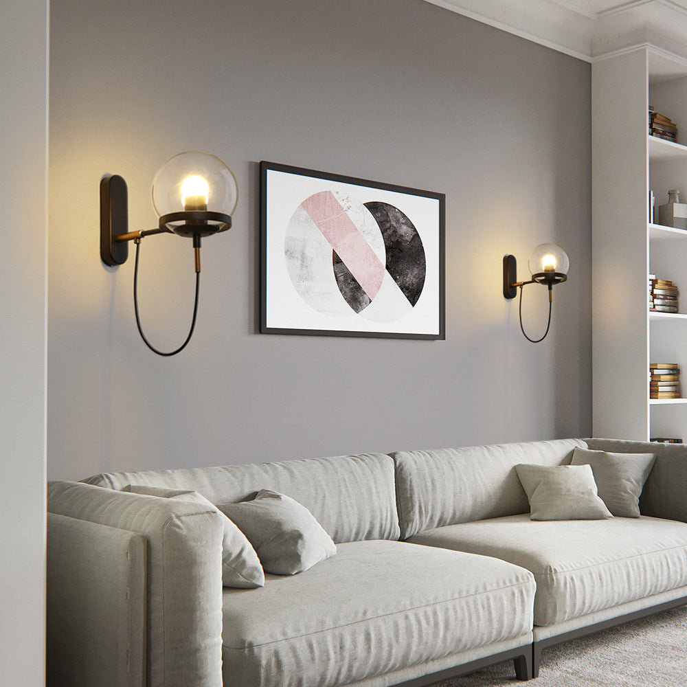 Modern living room with a gray sofa, wall sconces, and abstract art on a gray wall.