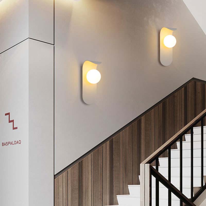Modern wall lights on a staircase with a visible brand logo.
