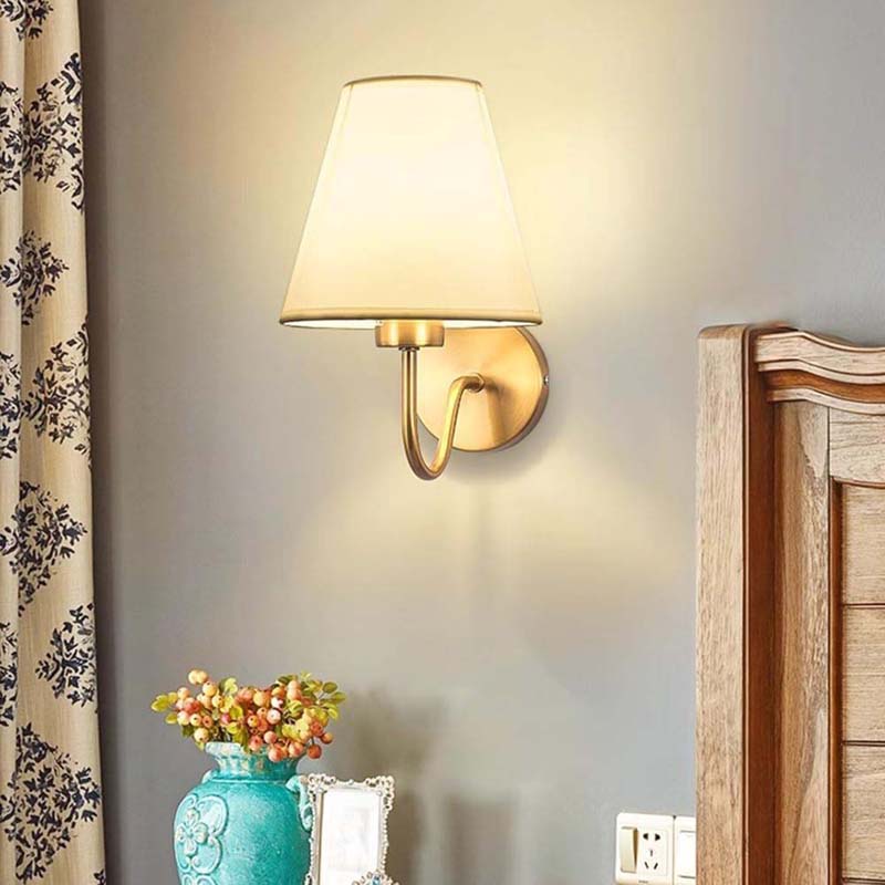 Wall-mounted lamp with a soft glow in a room setting.