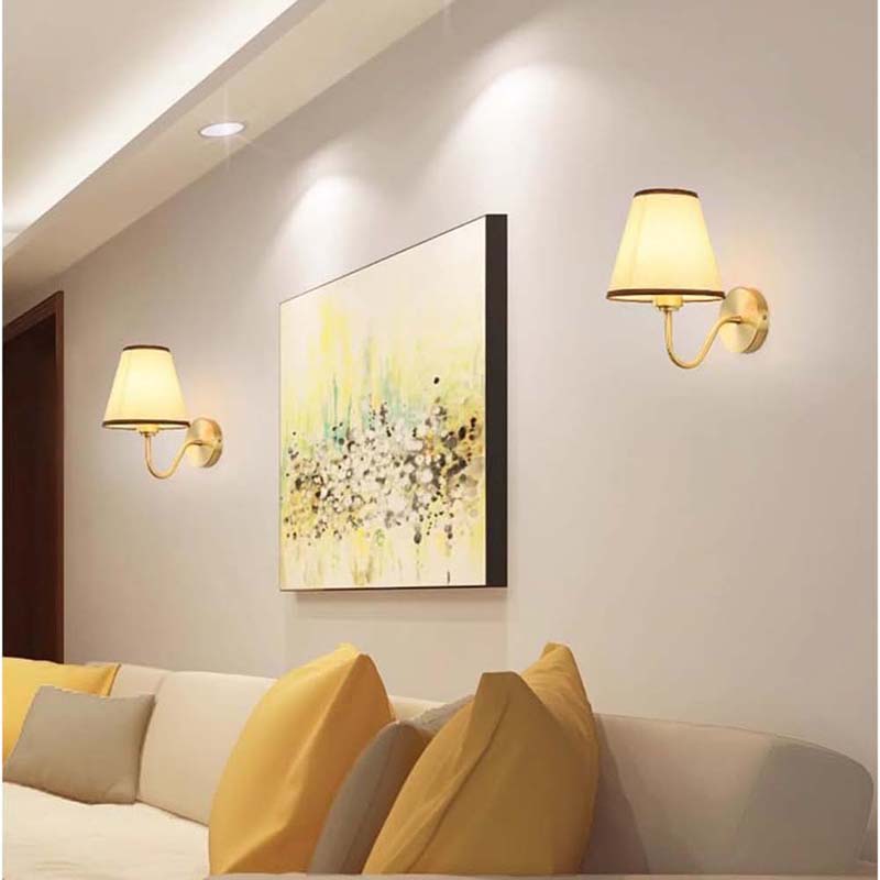 Living room with wall lights, abstract painting, and yellow cushions on a sofa.