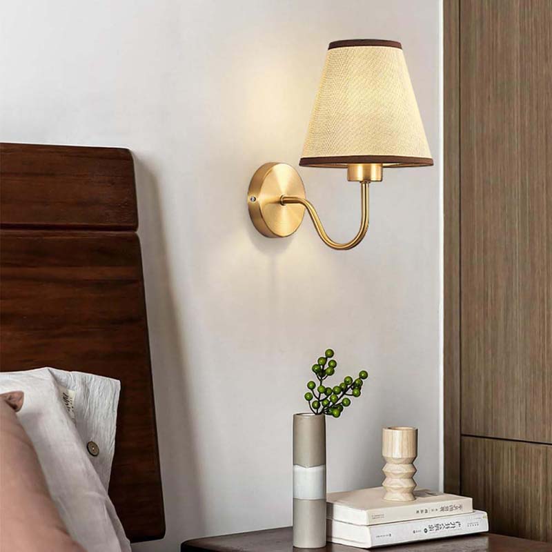 Wall-mounted lamp with a soft glow in a bedroom setting.
