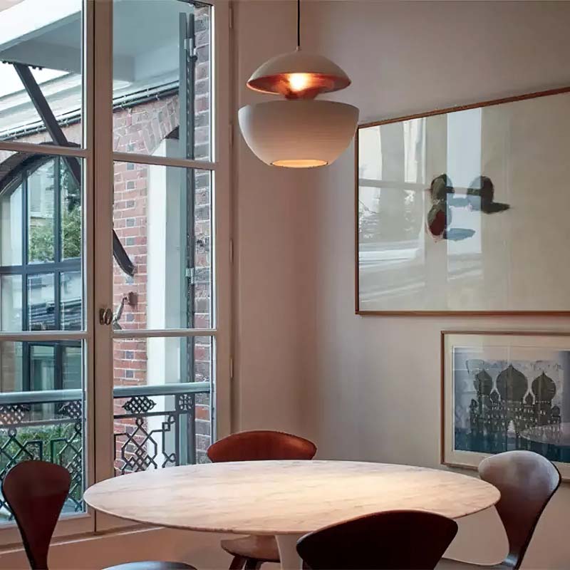 White Fire Sphere pendant light illuminating a dining table near large windows