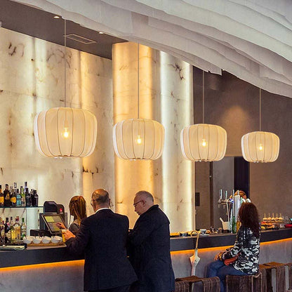 Lantern Pendant Light People mingle in a bar with modern interiors and lighting.