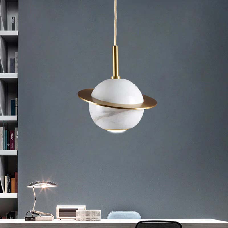 Modern pendant light with marble design hanging above a desk against a gray wall.