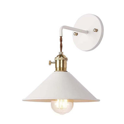 Wall-mounted light fixture with white shade and brass accents on a white background