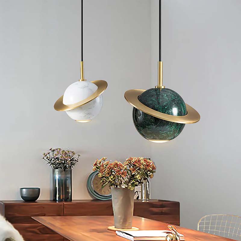 Two modern pendant lights hanging above a dining table with decorative items.