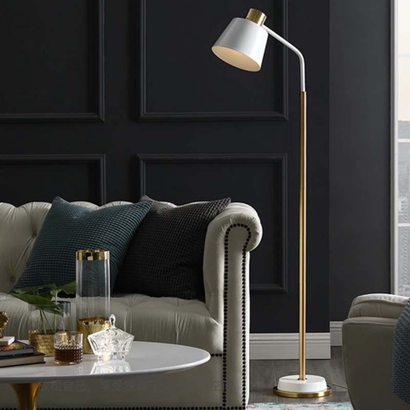 White floor lamp in a modern living room, next to a gray sofa, armchair and coffee table, against a background of dark paneling