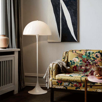 White floor lamp in living room with floral pattern sofa and abstract painting on wall