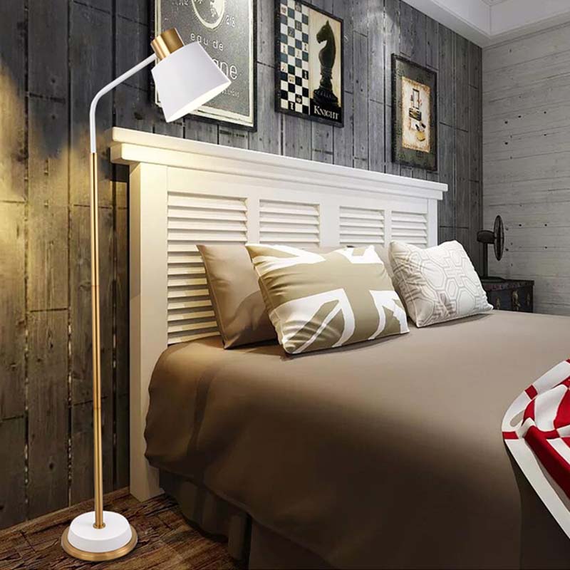White floor lamp next to the bed in the bedroom