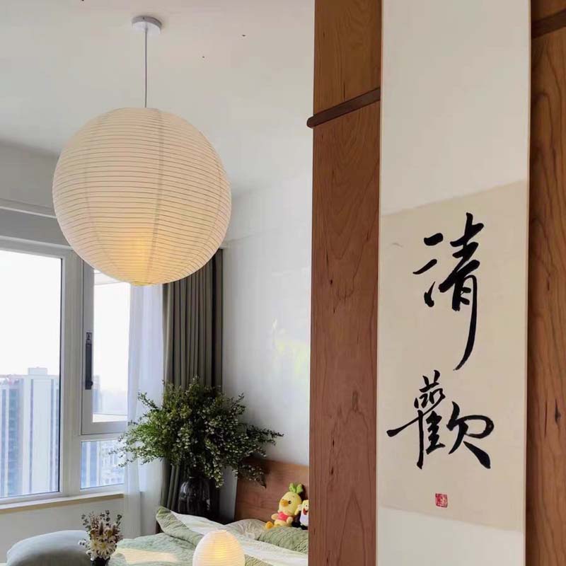 White paper lantern hanging in a modern bedroom with natural light.