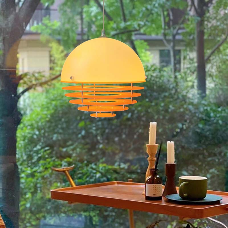 Yellow pendant lamp above a table by a window with garden view.